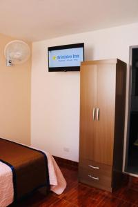 瓦尔梅Aristides Inn的卧室配有一张床,墙上配有电视。