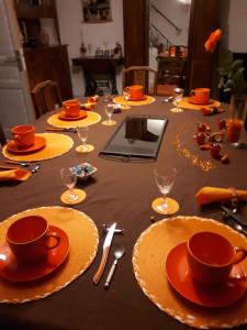 Saint-Laurent-de-la-PréeLa Roche bleue的一张桌子上放有橙色盘子和杯子