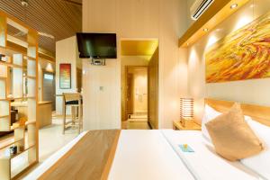 Turtle CoveOne ON Marlin Resort的卧室配有一张床铺,墙上配有电视