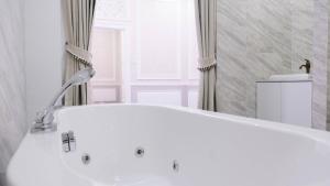 佛统VARIMANTRA HOTEL的带窗户的浴室内的白色浴缸