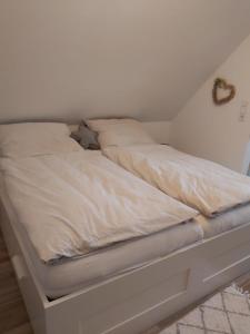 滕宁Huus Utspann的一张白色的床,坐在房间里