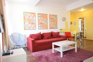 布加勒斯特Mosilor Apartments的客厅配有红色的沙发和桌子