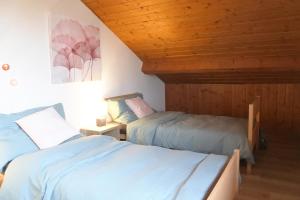 科泰洛特Cave du Cep的一间卧室设有两张床和木制天花板