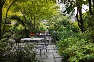 巴黎Hôtel Regent's Garden - Astotel的花园内带桌椅的庭院