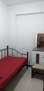 茂物Apartemen Bogor Valley Family Staycation的一间卧室配有红色的床和椅子