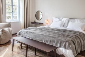 诺瓦利娅巴斯克那精品酒店的白色卧室配有一张大床和一张桌子