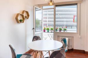 毕尔巴鄂Apartamento con vistas al Estadio San Mamés的窗户客房内的白色桌椅