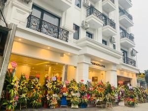河内Paragon Noi bai Hotel & Pool的前面有一堆鲜花的建筑