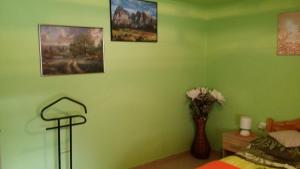 NemesdédZeg-zug Vendégház的绿色卧室,配有一张床和花瓶