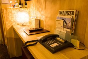 美因茨Hotel Hammer-Mainz Hauptbahnhof的办公室桌子上的黑色电话