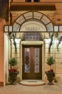 科特布斯阿姆希特老城酒店的一座拥有门和两株植物的酒店入口