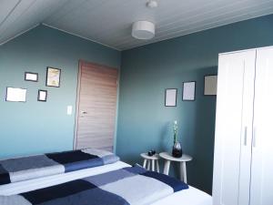 Gernrode - HarzFerienwohnung Harzdomizil的一间拥有蓝色墙壁的卧室,配有一张床和两张桌子