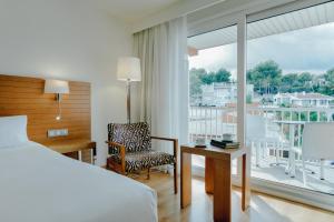 马略卡岛帕尔马Hesperia Ciudad de Mallorca的卧室配有床、椅子和窗户。