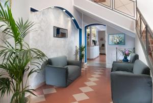 里米尼Hotel Cheri的建筑里带椅子和植物的走廊