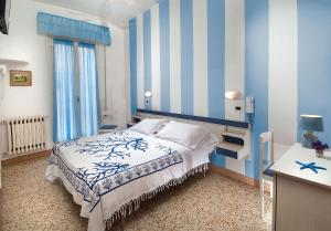 里米尼Hotel Cheri的一间卧室配有一张蓝色和白色条纹的床