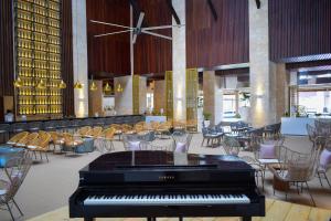 蓬塔卡纳Grand Bavaro Princess - All Inclusive的大堂的钢琴,配有桌椅