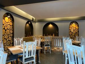 锡纳亚罗伯托酒店 的用餐室配有木桌和白色椅子
