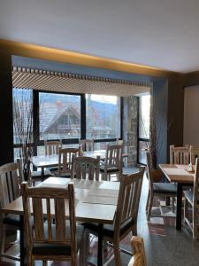 锡纳亚罗伯托酒店 的餐厅设有桌椅和大窗户。