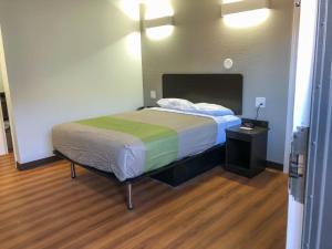 威奇托Studio 6 Wichita, KS - Airport的一间卧室配有一张带绿色和白色毯子的床