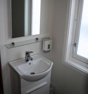 Offersøy奥夫尔塞岛垂钓中心酒店的一间带水槽和镜子的浴室以及窗户。