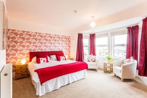 多切斯特Aquila Heights Guest House的卧室设有红色和白色的床和窗户。
