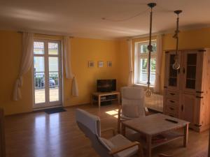 卢布明Ferienhaus Schwalbe Seebad Lubmin的客厅设有黄色的墙壁和桌椅