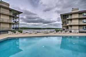 奥沙克湖Waterfront Lake Ozark Condo with Deck and Pools的一座带椅子的大型游泳池和一座建筑