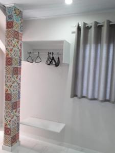索罗卡巴Casa do Henrique 2的一间设有窗帘和鞋架的房间