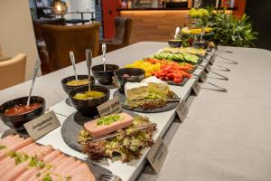 赫尔辛堡Dream - Luxury Hostel的餐桌上的自助餐,包括食物