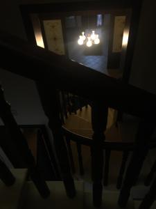 苏尔博B&B La Stella的一间设有楼梯和吊灯的黑暗客房