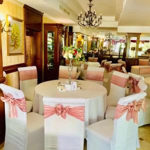 巴克乌Vila Royal的用餐室配有桌椅和弓形