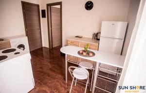哈尔基斯Explore Greece from Lovely City Centre Apartment的厨房配有白色冰箱、桌子和椅子