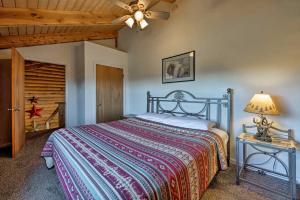 摩押Cabin with Fire Pit, Views and BBQ 18 Mi to Moab!的一间卧室配有一张床和一张带台灯的桌子
