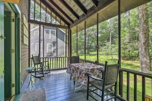 Lake ClearSaranac Lake Cabin with Beach Access的门廊上设有桌椅,