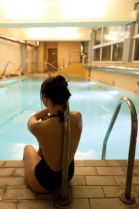 巴尼－迪卢卡巴尼二卢卡酒店及温泉的坐在游泳池旁的女人