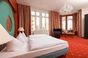 科特布斯阿姆希特老城酒店的卧室配有白色的床和吊灯。