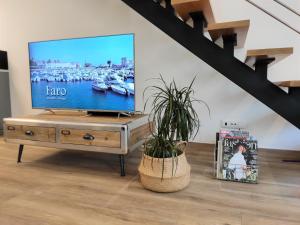 法鲁Casa da Mouraria的客厅配有木桌上的电视