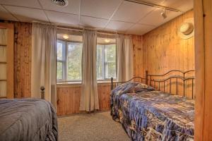 HesstonPet-Friendly Raystown Lakefront Cabin with BBQ Grill的一间卧室设有两张床和窗户。