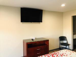 Wood RiverBEL AIR MOTEL的卧室配有一张床,墙上配有电视。