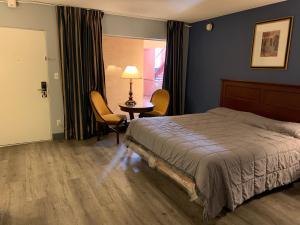 拉斯维加斯市中心汽车旅馆的卧室配有一张床和一张桌子及椅子