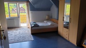 科尔别卢夫OKW Pilsko的一间卧室设有一张床,并有通往阳台的门