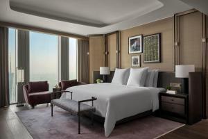 广州广州瑰丽酒店的卧室配有一张白色大床和一把椅子