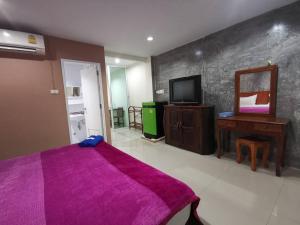 宋卡Ban Kaew Guesthouse Songkhla的一间卧室配有一张紫色的床和镜子