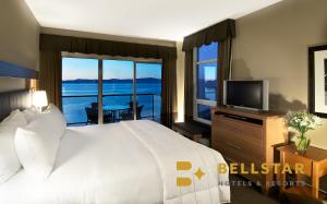 帕克斯维尔海滩俱乐部度假村 - 贝斯塔酒店&度假村的一间卧室配有一张床、一台电视和一个阳台