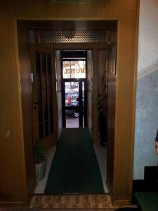 米兰阿卡普尔科酒店的门前铺着绿色地毯的走廊