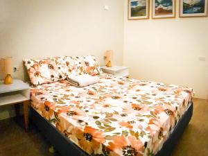 利帕数不胜数建设者宾馆的一间卧室配有一张带花卉棉被的床
