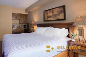 戈尔登冰川登山旅馆的一间卧室配有一张带白色床单的大床