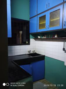 钦奈Sai Baba Service Apartments的厨房配有蓝色橱柜和水槽