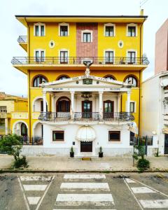 伊格莱西亚斯Euro Hotel Iglesias的黄色和白色的建筑,设有阳台