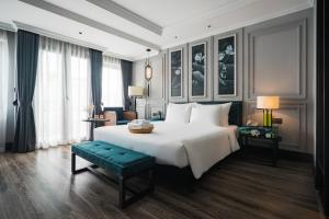 河内Solaria Hanoi Hotel的卧室配有一张白色大床和绿色长凳